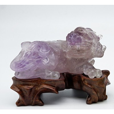 Chinese Carved Amethyst Model of a Buddhist Lion on a Carved Hardwood Stand, 20th Century