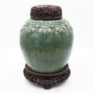 Antique Chinese Green Glazed Stoneware Jar with a Moulded Ruyi Border, Pierced and Carved Hardwood Stand and Cover