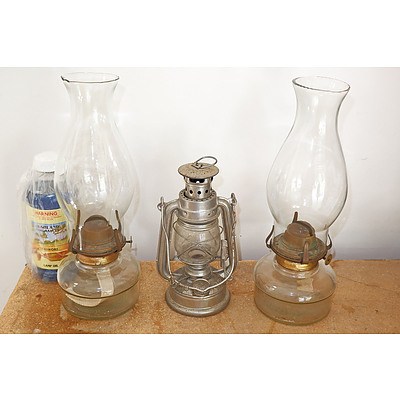 Two Glass Oil Lamps with Flues Together with a Hurricane Lamps and Bottle of Lamp Oil (3)