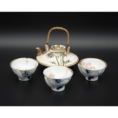 Small Japanese Satsuma Teapot with Wicker Handle and Three Porcelain Cups from Another Kiln