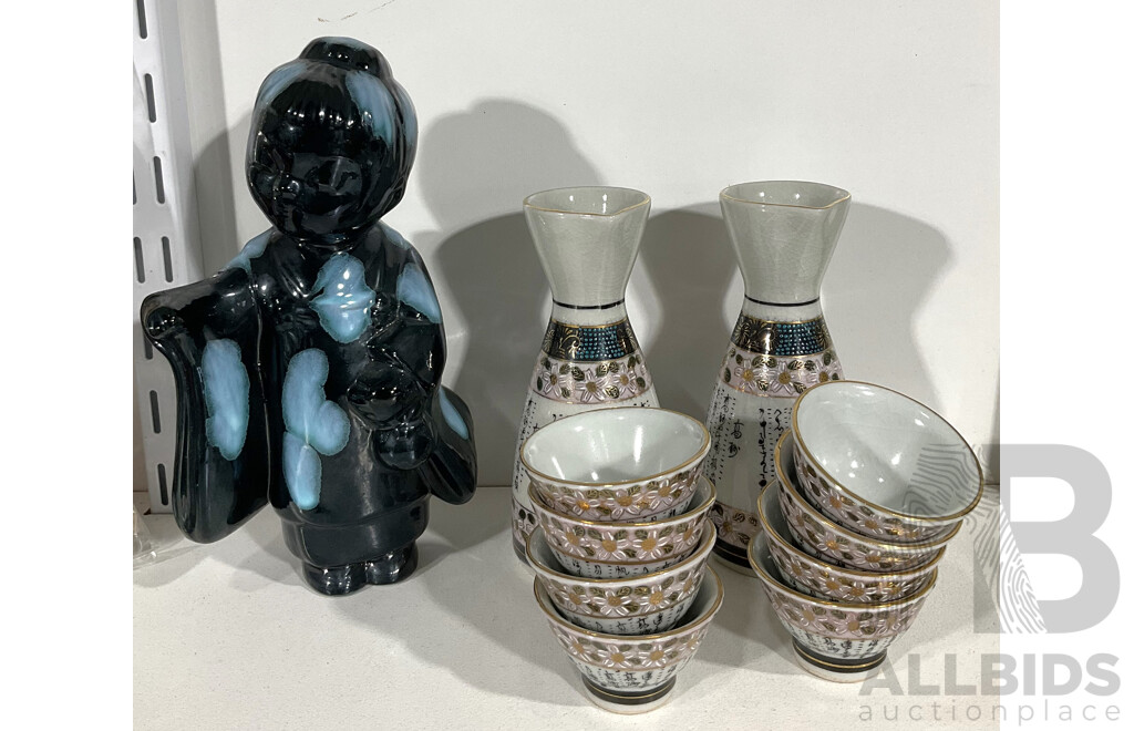 Pair of Decorative Saki Sets - One Jug Each with Four Cups, Alongside a Geisha Figurine