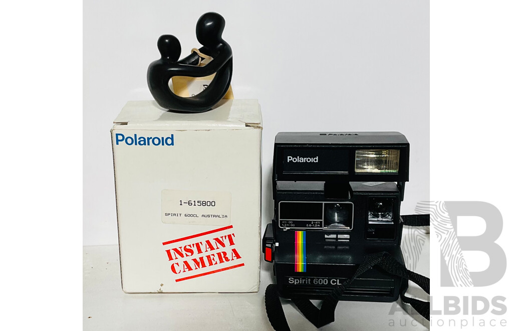 Vintage Polaroid Spirit 600 CL Camera with Original Box and Instructions Alongside a Parent and Child Figurine