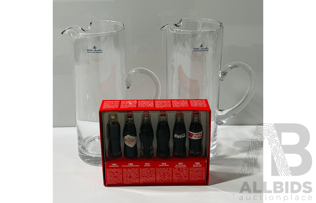 Pair of Wilkie Brothers Handmade Glassware Jugs Alongside Evolution of the Coca Cola Contour Bottle Memorabilia Item