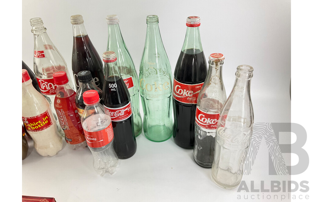 Collection of New and Old Coca Cola Bottles Including Tall Glass One Liter and Plastic T Shirt in a Bottle