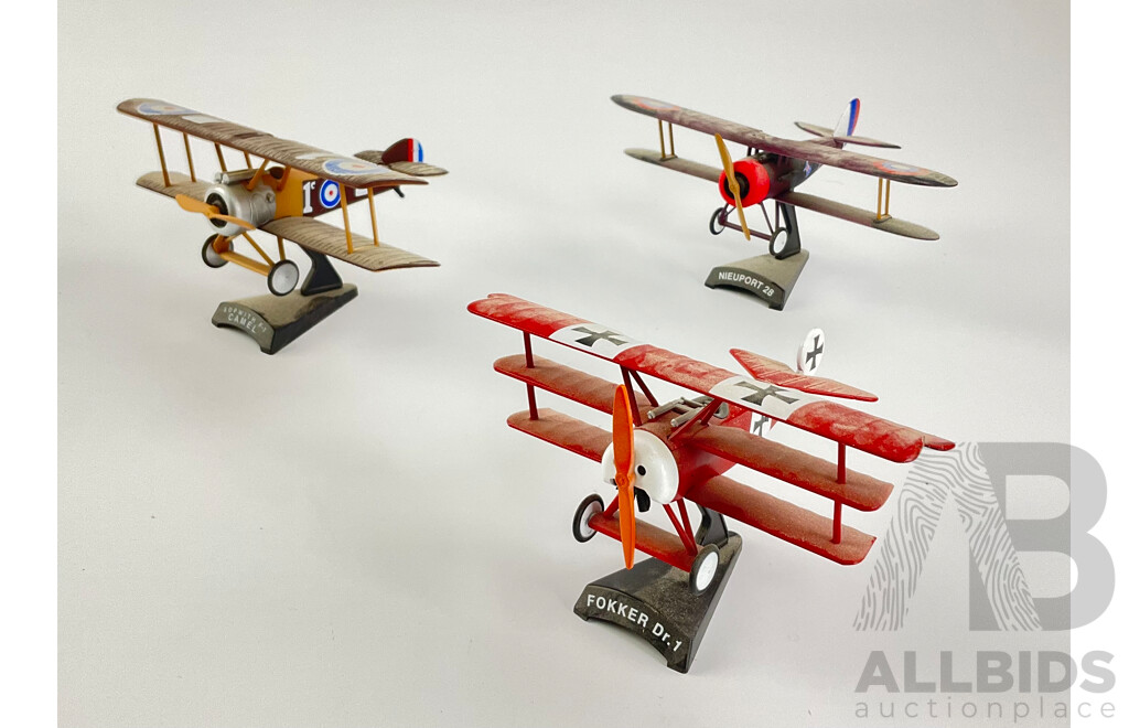 Three Diecast WW1 Era Aircraft on Display Stands Including Sopwith F-1 Camel, Fokker DR-1, Nieuport 28